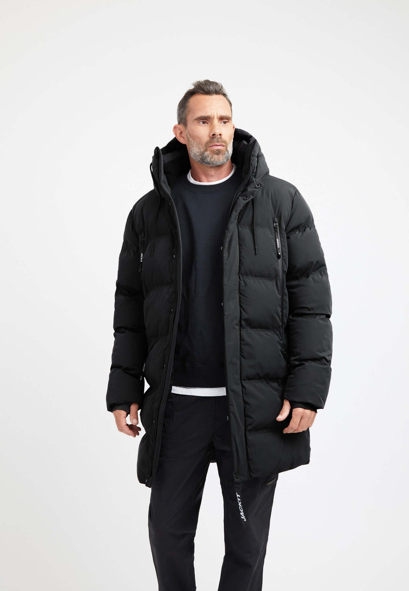 Man wearing a Supremo Coat Black, a stylish short puffer coat with insulation and technical features.