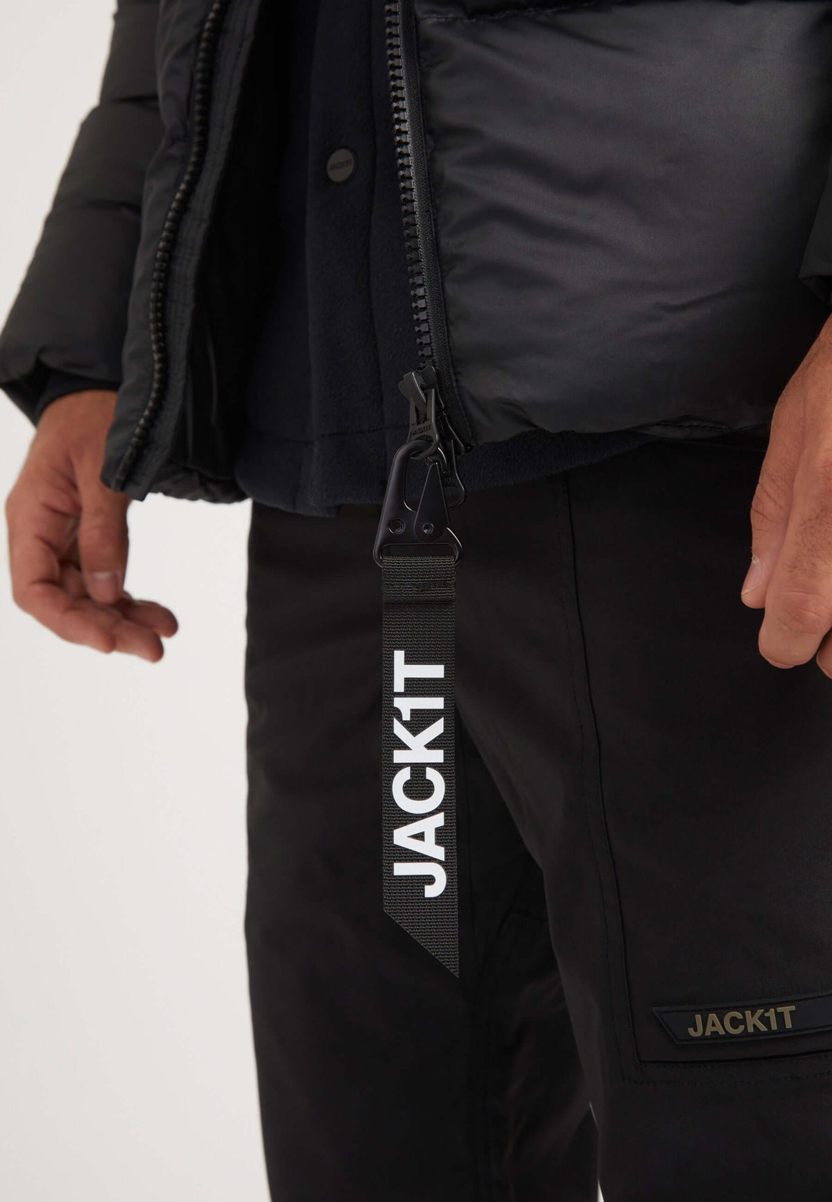 Mens black parka featuring zip closure and logo tag for style and convenience.