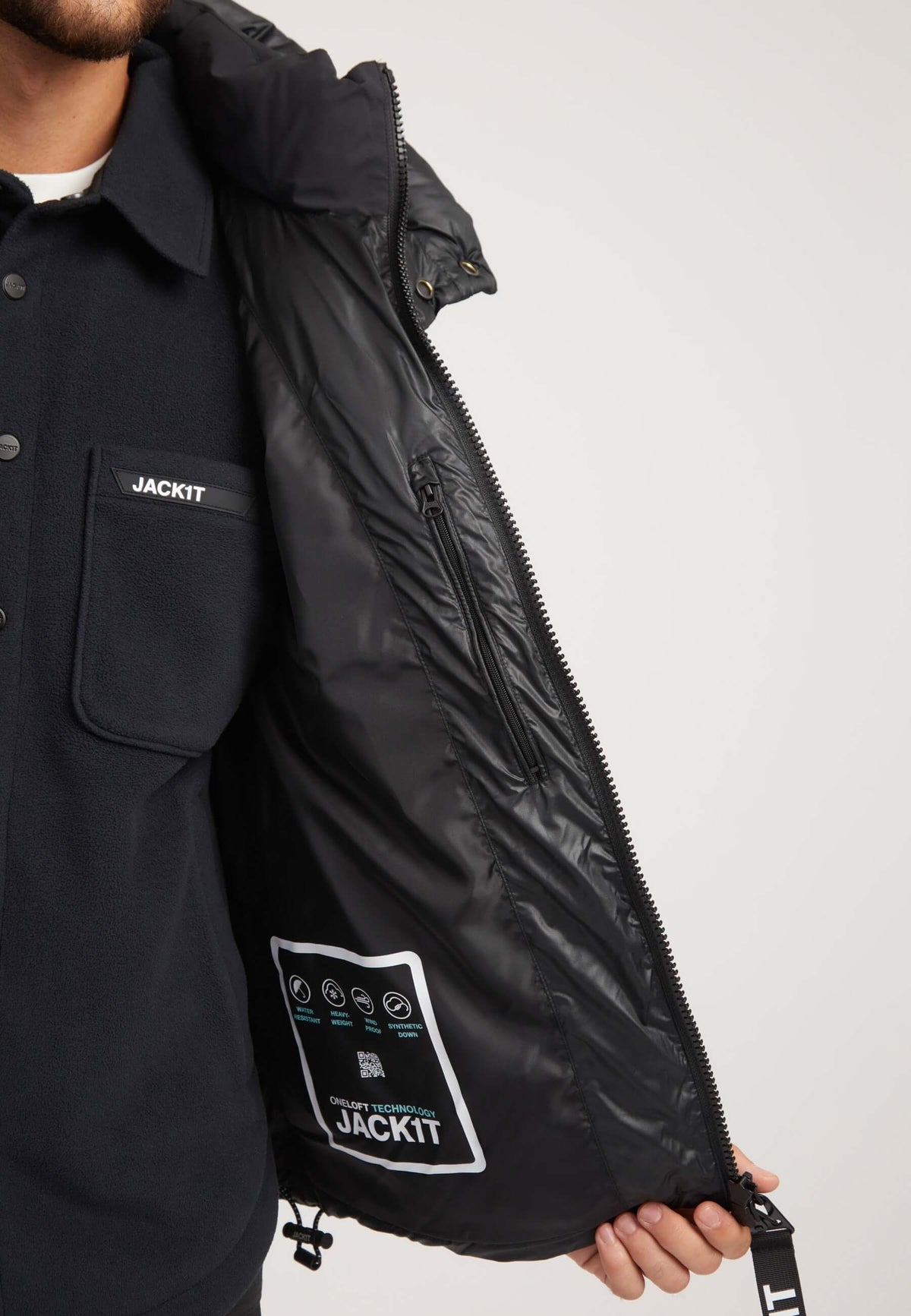 Mens black parka featuring a boxy fit and oversized hood, showcasing interior insulation and care label.