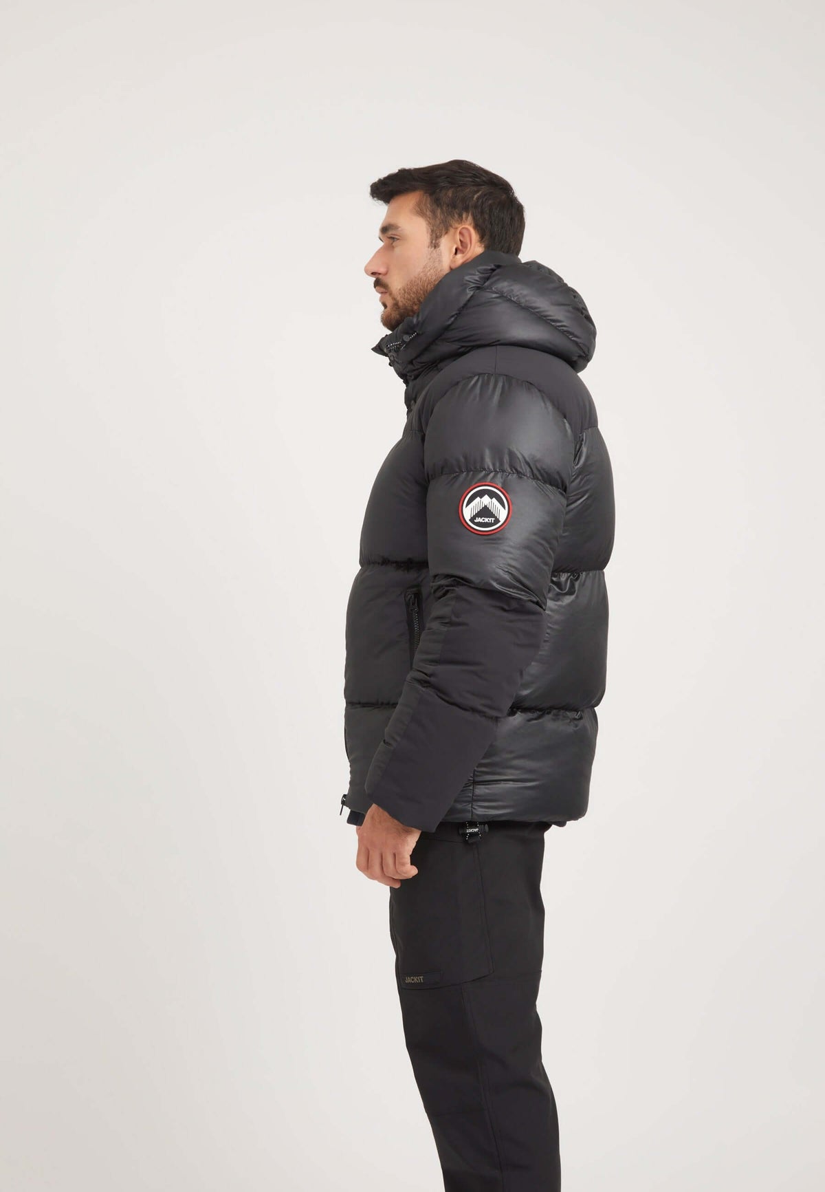 Mens black parka displayed on a model, showcasing its boxy fit and oversized removable hood.