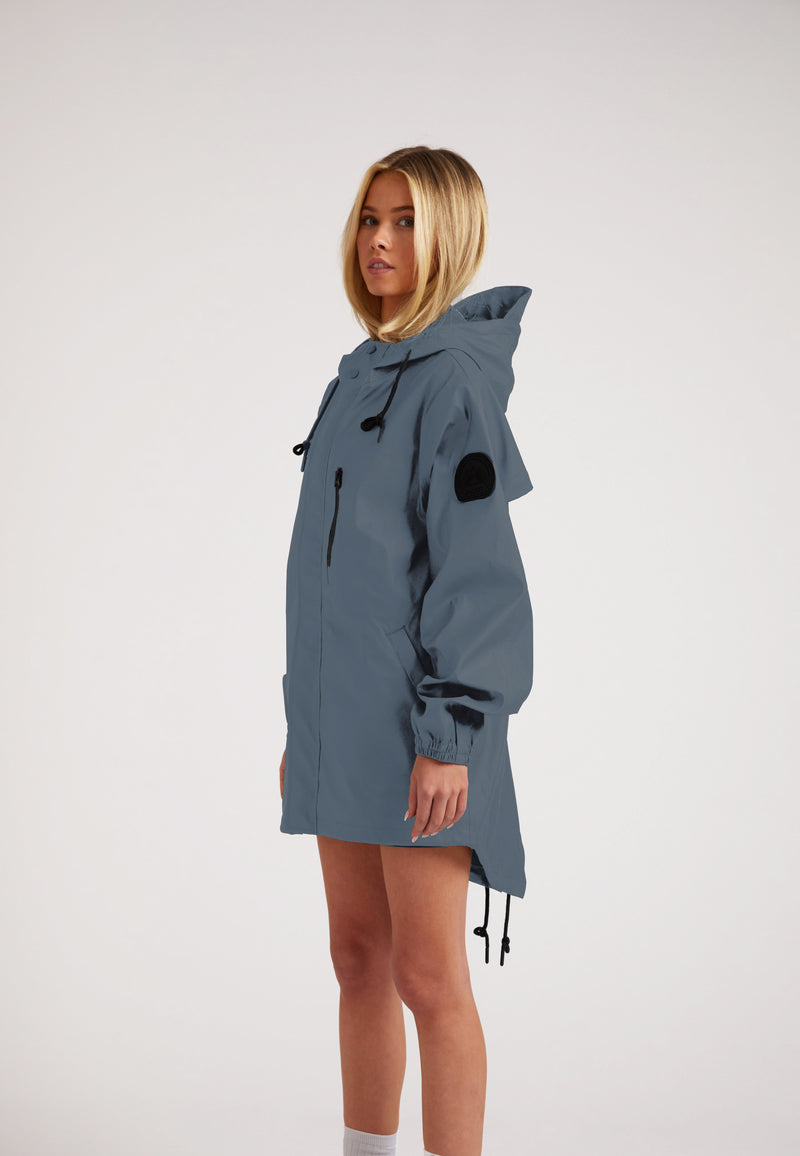 Woman wearing ELEMENTS Raincoat 2.0 Grey, showcasing its stylish design and practical features.
