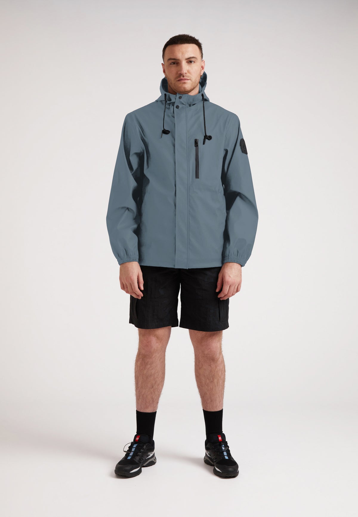 Man wearing the ELEMENTS Unisex Raincoat 2.0 Grey, showcasing its stylish design and versatility.