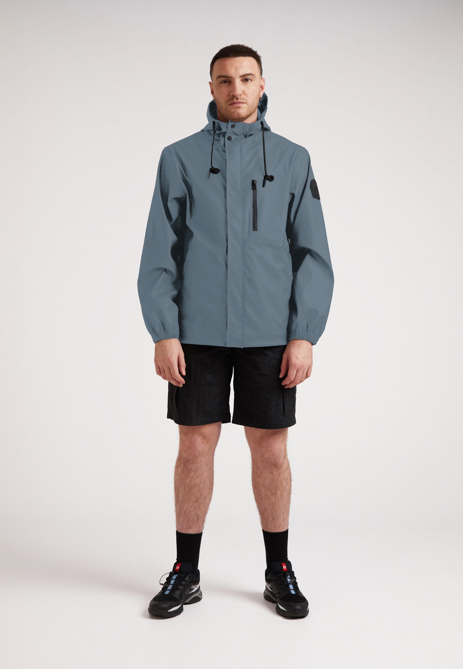 Man wearing the ELEMENTS Unisex Raincoat 2.0 Grey, showcasing its stylish design and versatility.