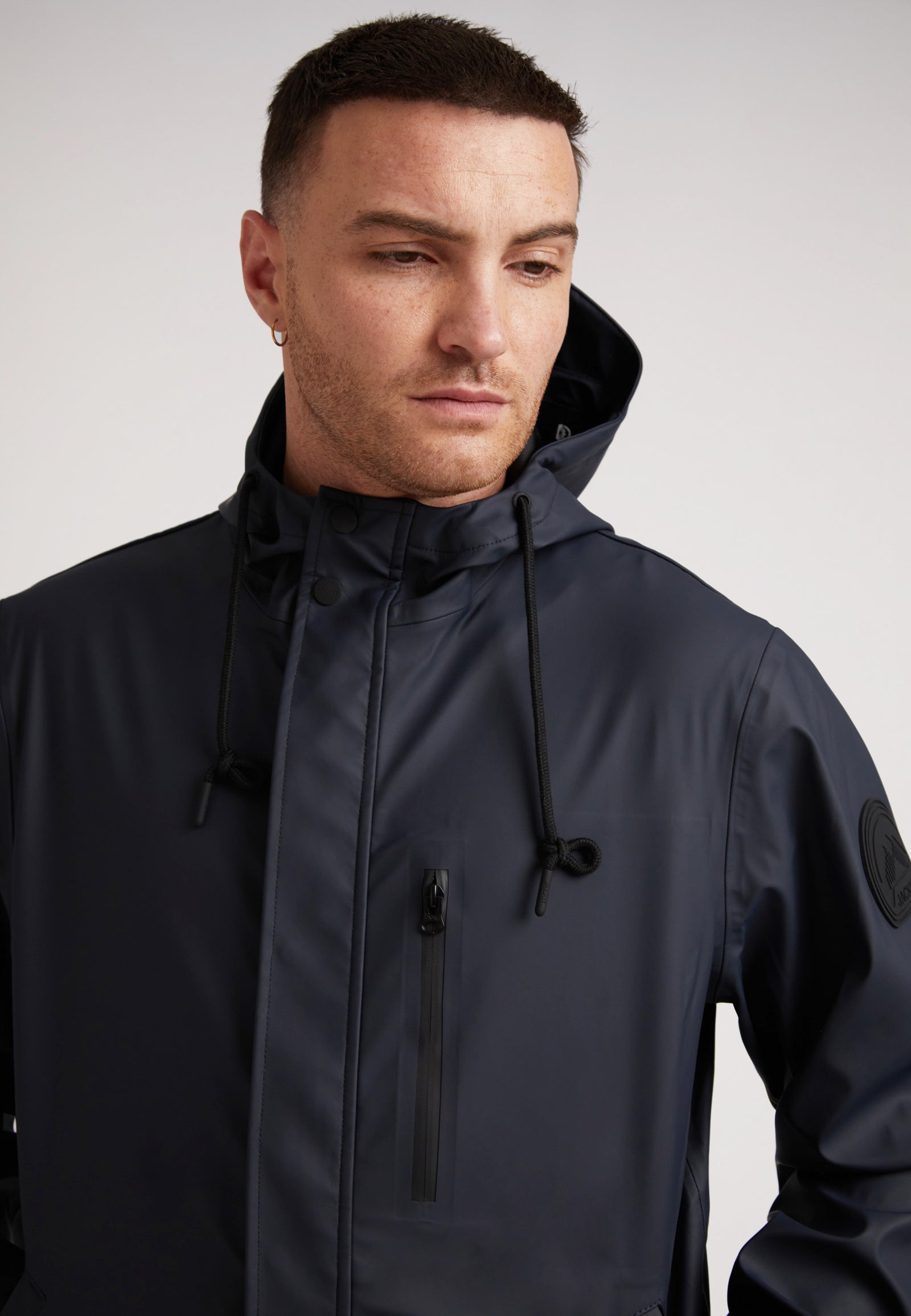 Model showcasing the ELEMENTS Unisex Raincoat 2.0 Navy, featuring a sleek design and adjustable hood.