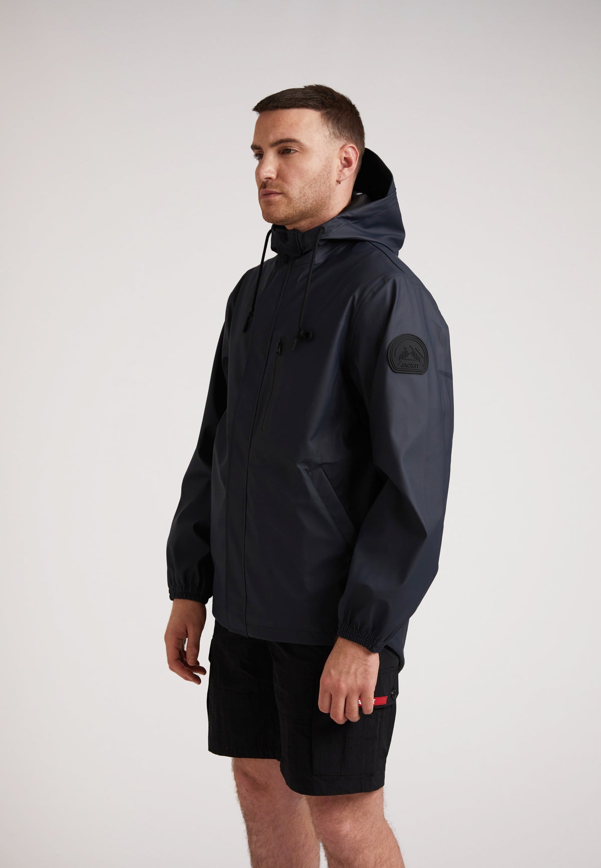 Man modeling ELEMENTS Unisex Raincoat 2.0 Navy, showcasing its lightweight design and weather protection features.