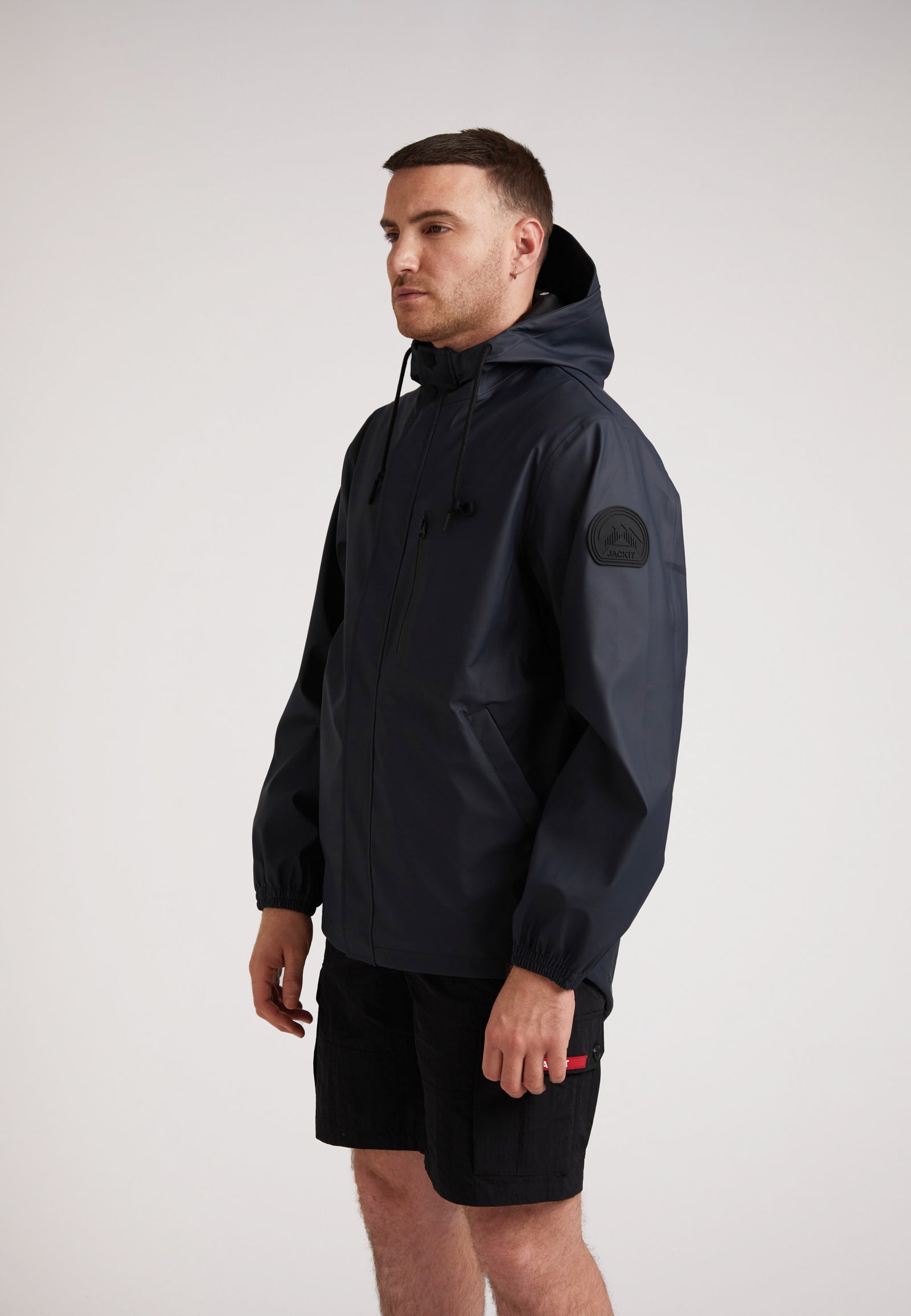Man modeling ELEMENTS Unisex Raincoat 2.0 Navy, showcasing its lightweight design and weather protection features.