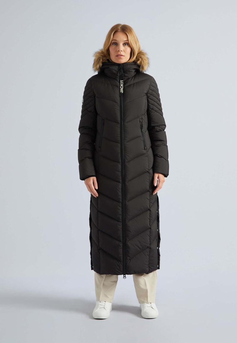 Woman wearing a long puffer coat womens in black with a fur-lined hood, showcasing a stylish full-length design.