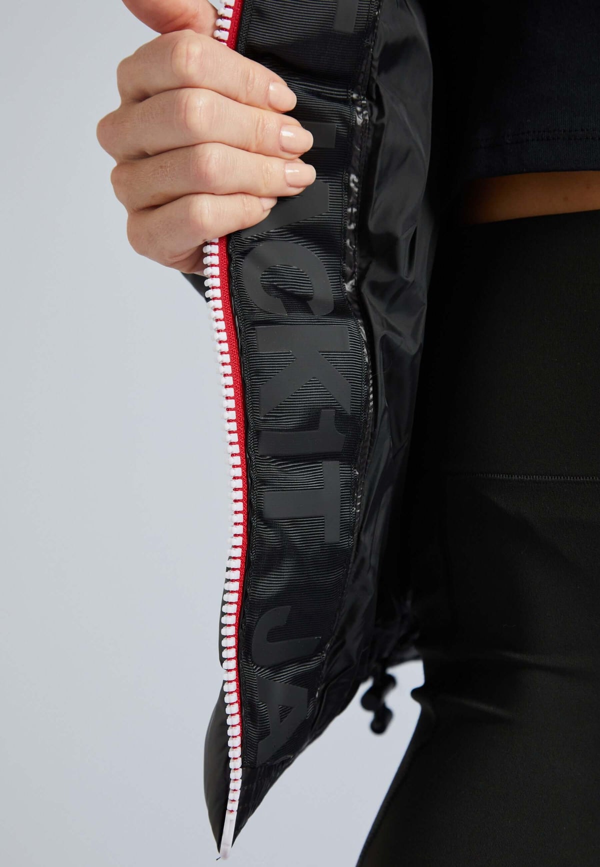 Close-up of R3D Tricolore black puffer jacket with fur hood, showcasing zipper detail and interior design.