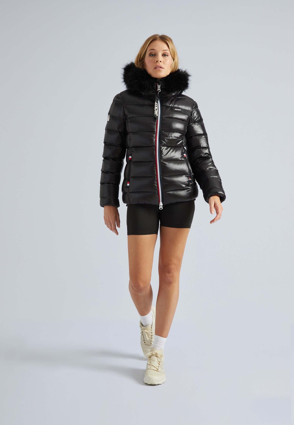 Model wearing a stylish Black puffer jacket with fur hood, showcasing a sleek fit and contemporary design.