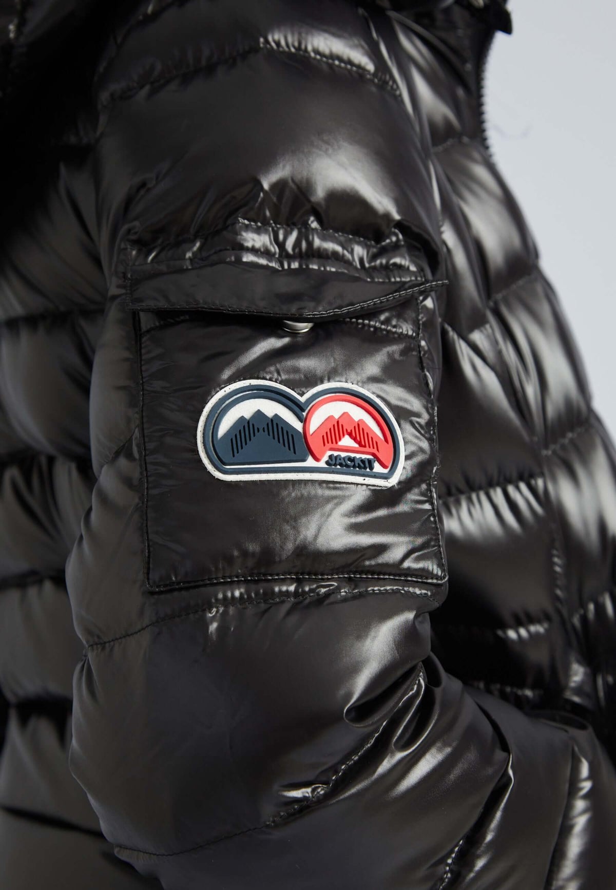 Close-up of the Squadra Slick Racer Jacket Black with logo patch on the sleeve, showcasing the stylish design of this black puffer jacket womens.