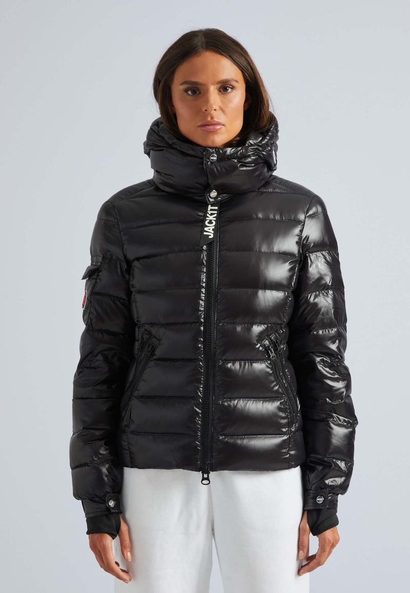 Model wearing a black puffer jacket womens with a detachable hood and a sleek finish.