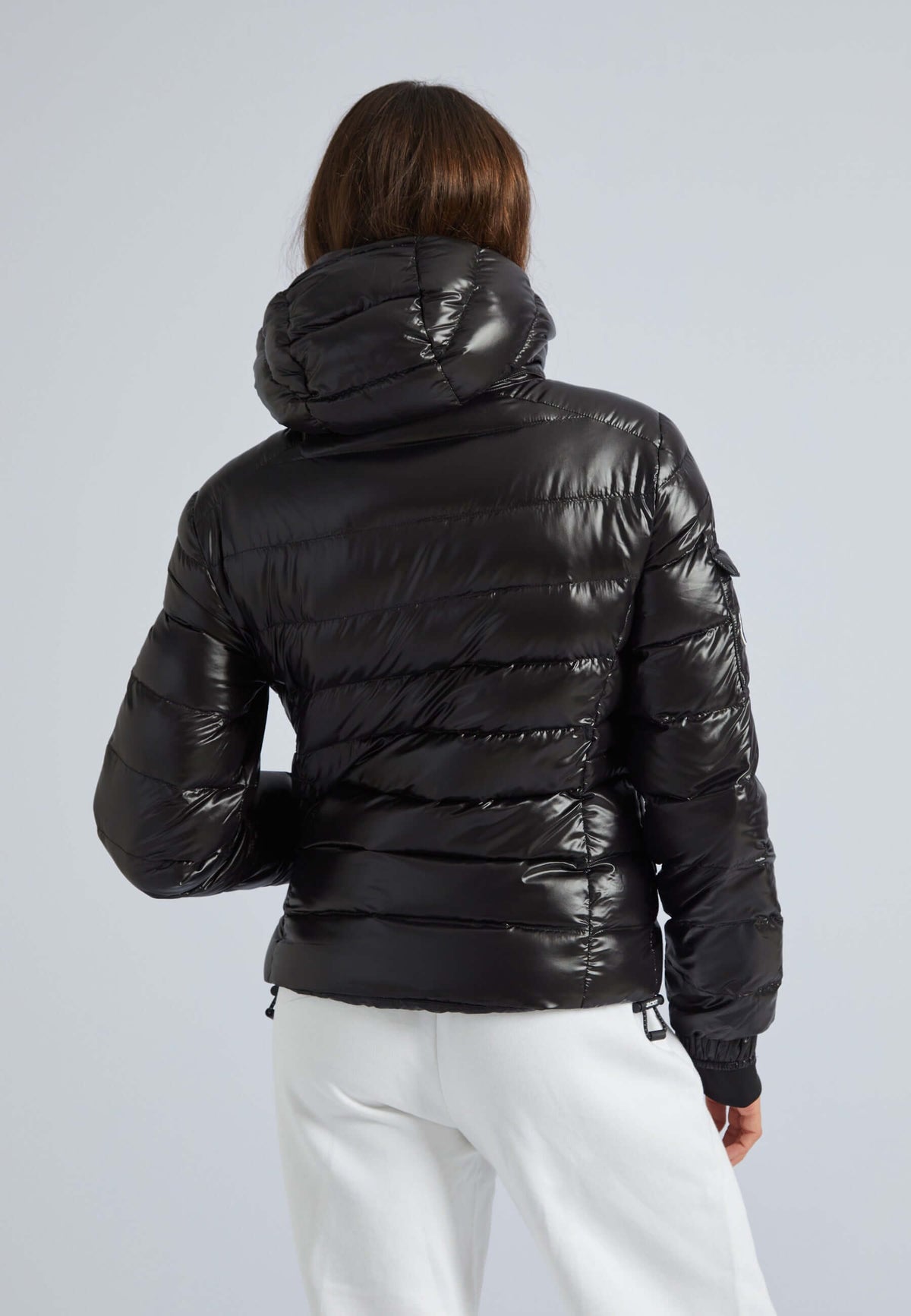 Black puffer jacket womens, back view with a detachable hood for a sleek urban style.