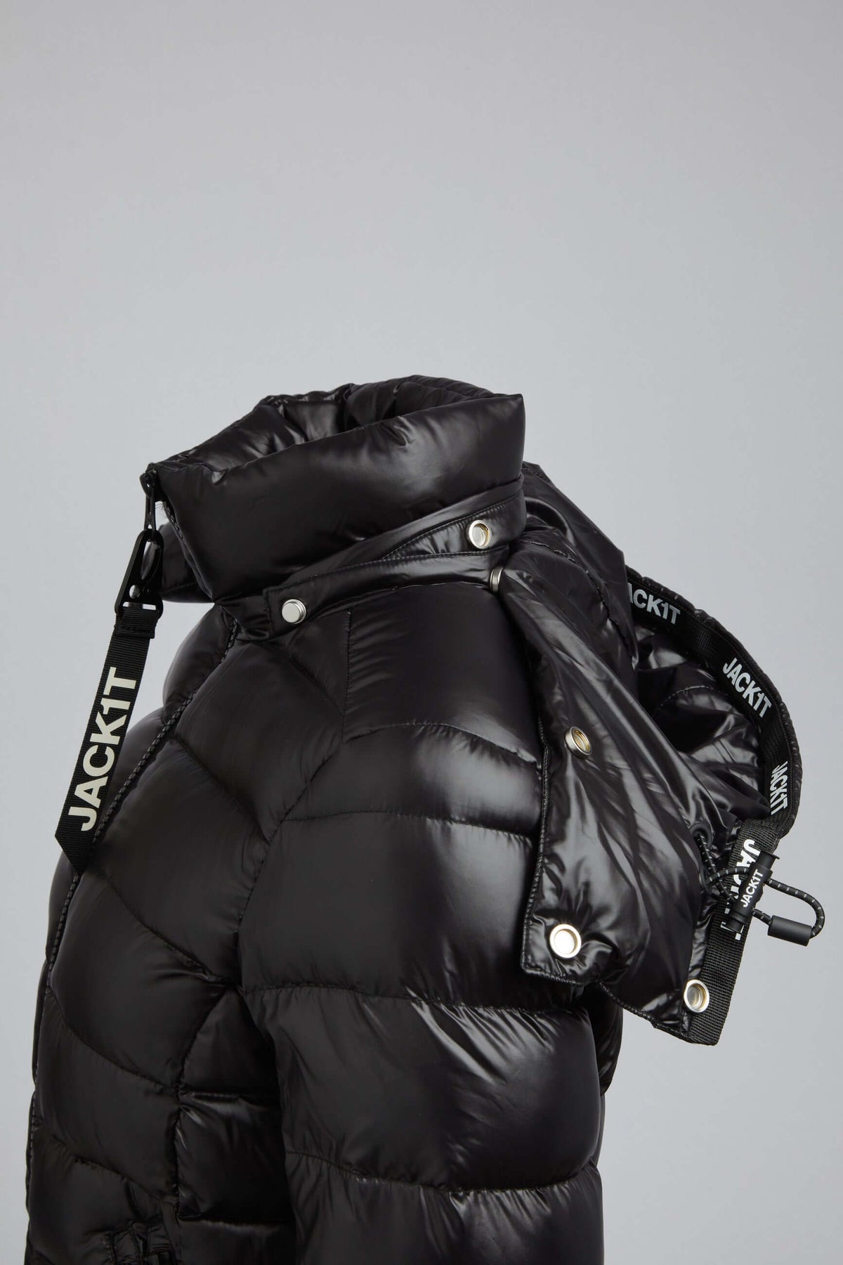 Side view of Squadra Slick Racer Black Puffer Jacket Womens featuring detachable hood and sporty silhouette.