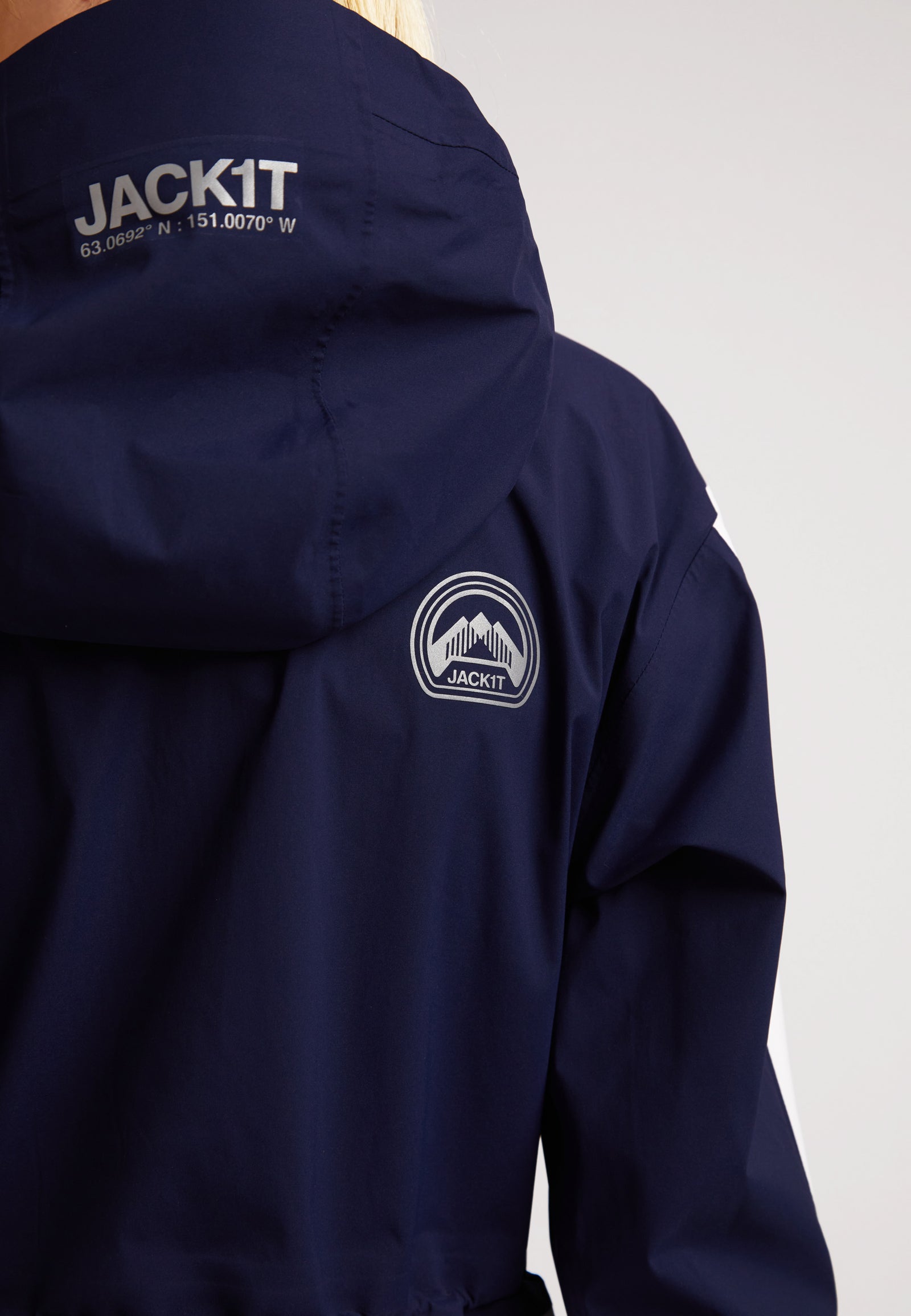 Ladies waterproof lightweight navy jacket featuring a hood and logo details on the back.