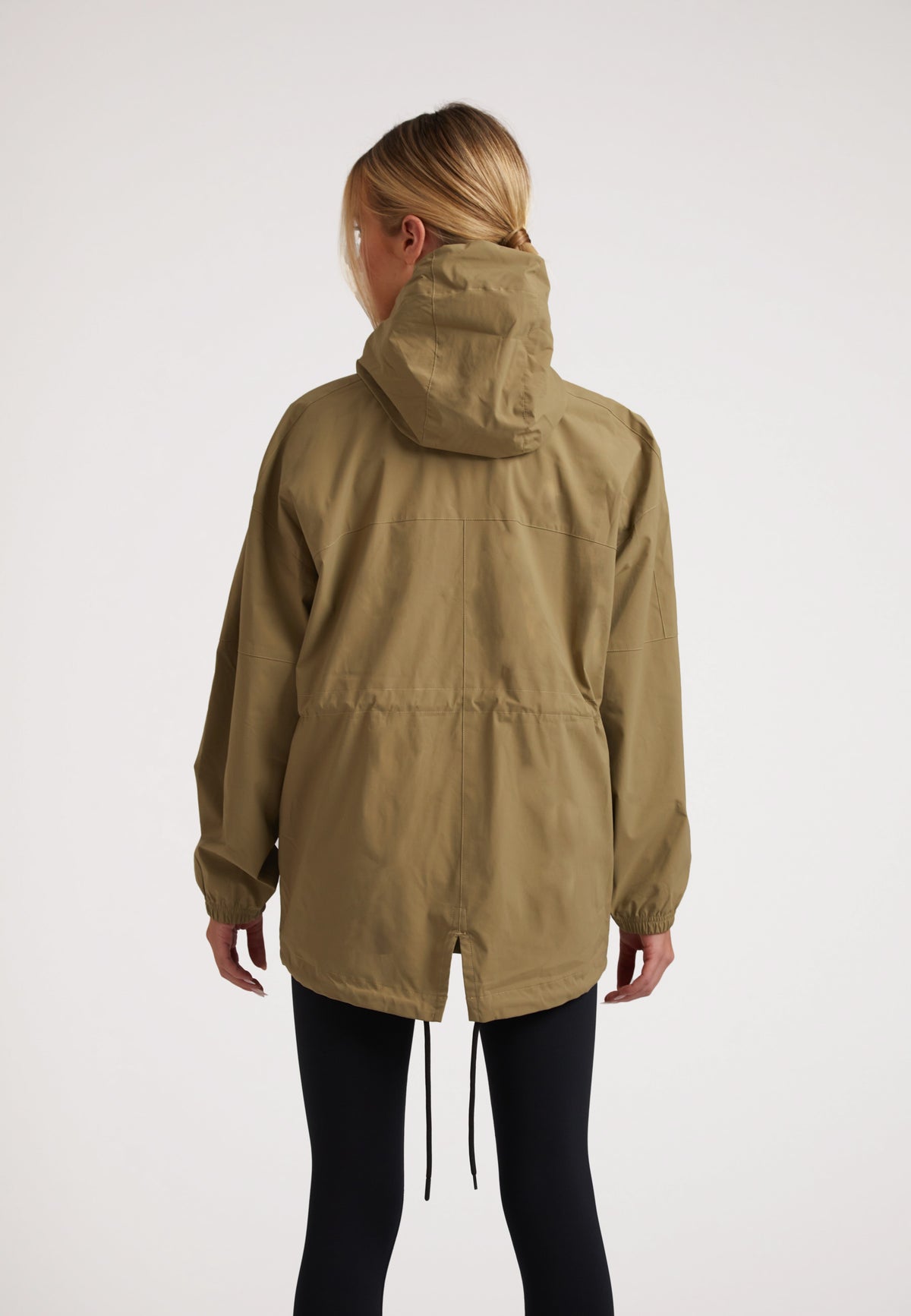 Rear view of a model wearing Ladies lightweight olive windbreaker with hood and drawstring hem