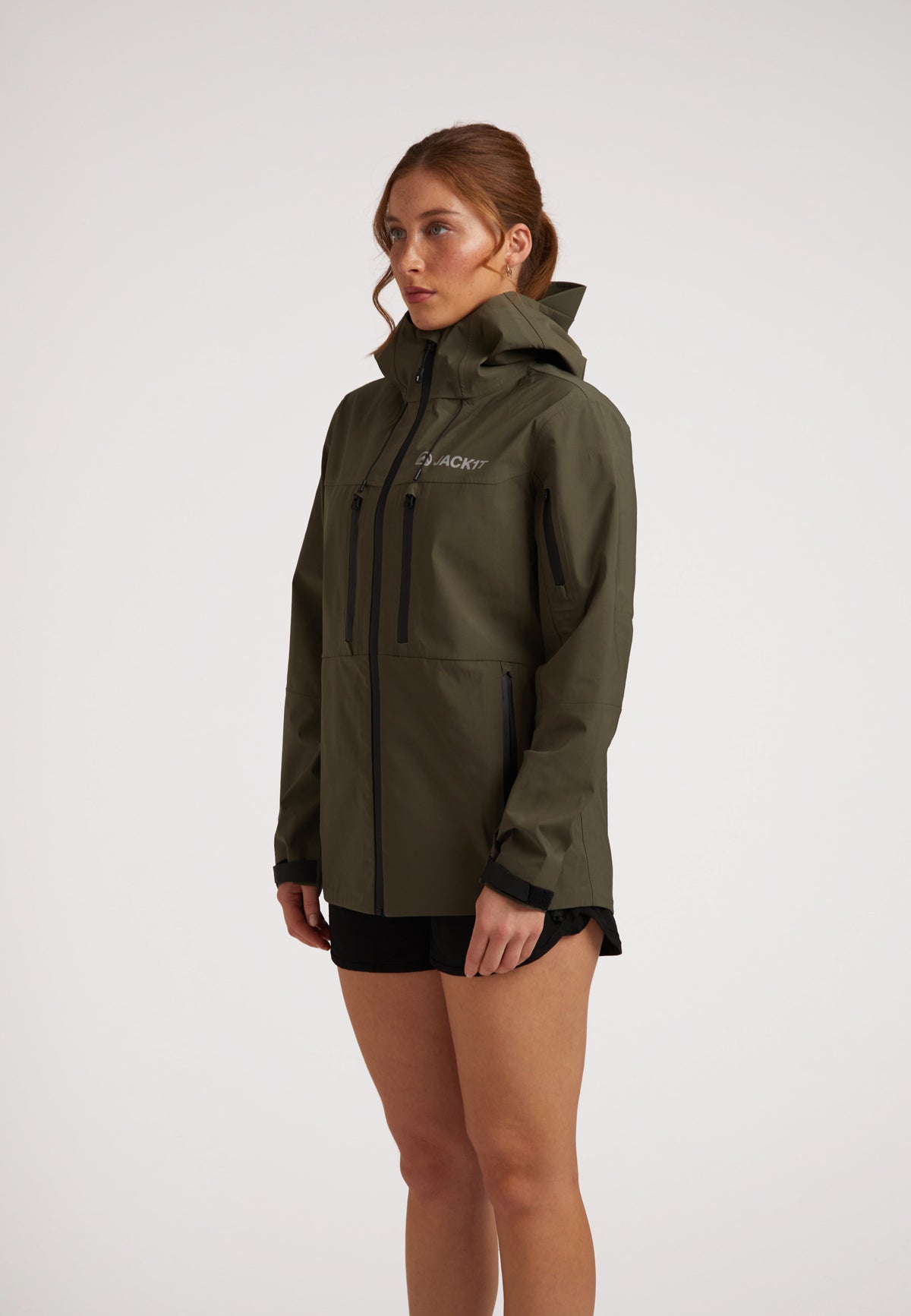 Waterproof ladies jacket in olive, featuring a hood and multiple pockets, designed for outdoor protection.
