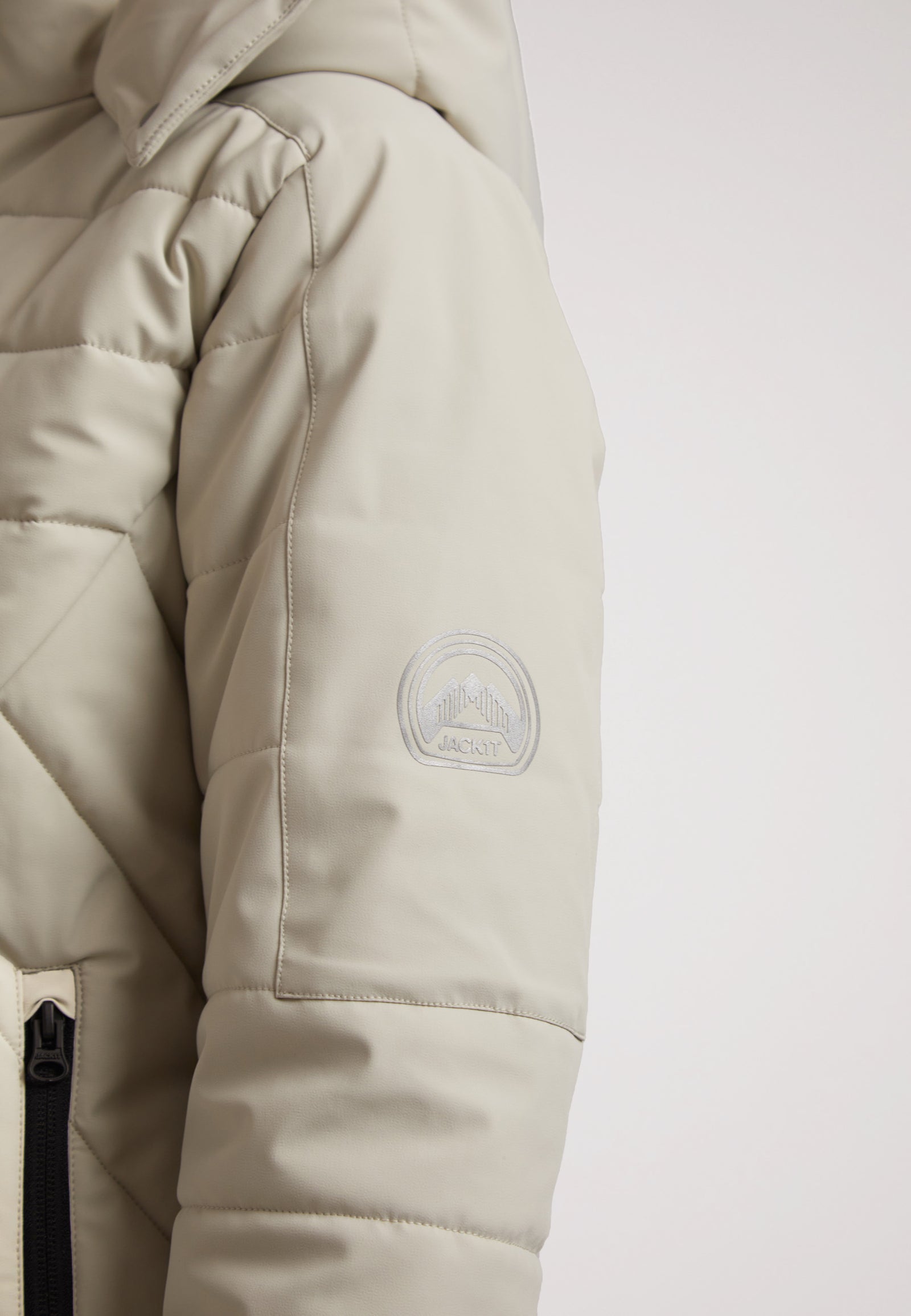 Close-up of the ISOTOPE Ladies padded lightweight stone jacket showing the shoulder and logo detail.
