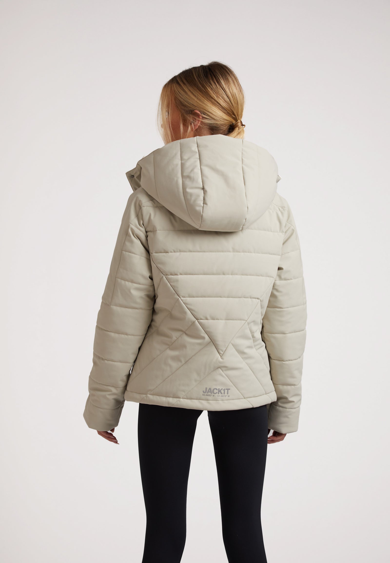Back view of a model wearing an ISOTOPE Ladies padded lightweight stone jacket with hood.
