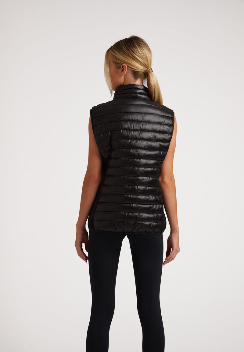Back view of a woman wearing the SPORTL1TE Funnel Lightweight Gilet 2.0 Lux Black, showcasing its sleek design and lightweight fabric.