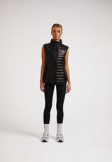Woman wearing SPORTL1TE Funnel Lightweight Gilet 2.0 Lux Black, showcasing sleek design and modern style.