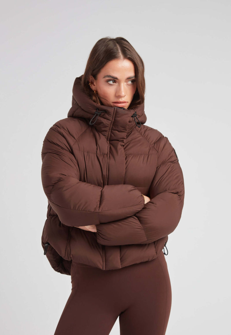 Short puffer jacket women in mocha color with oversized hood and cropped cut for a modern silhouette.