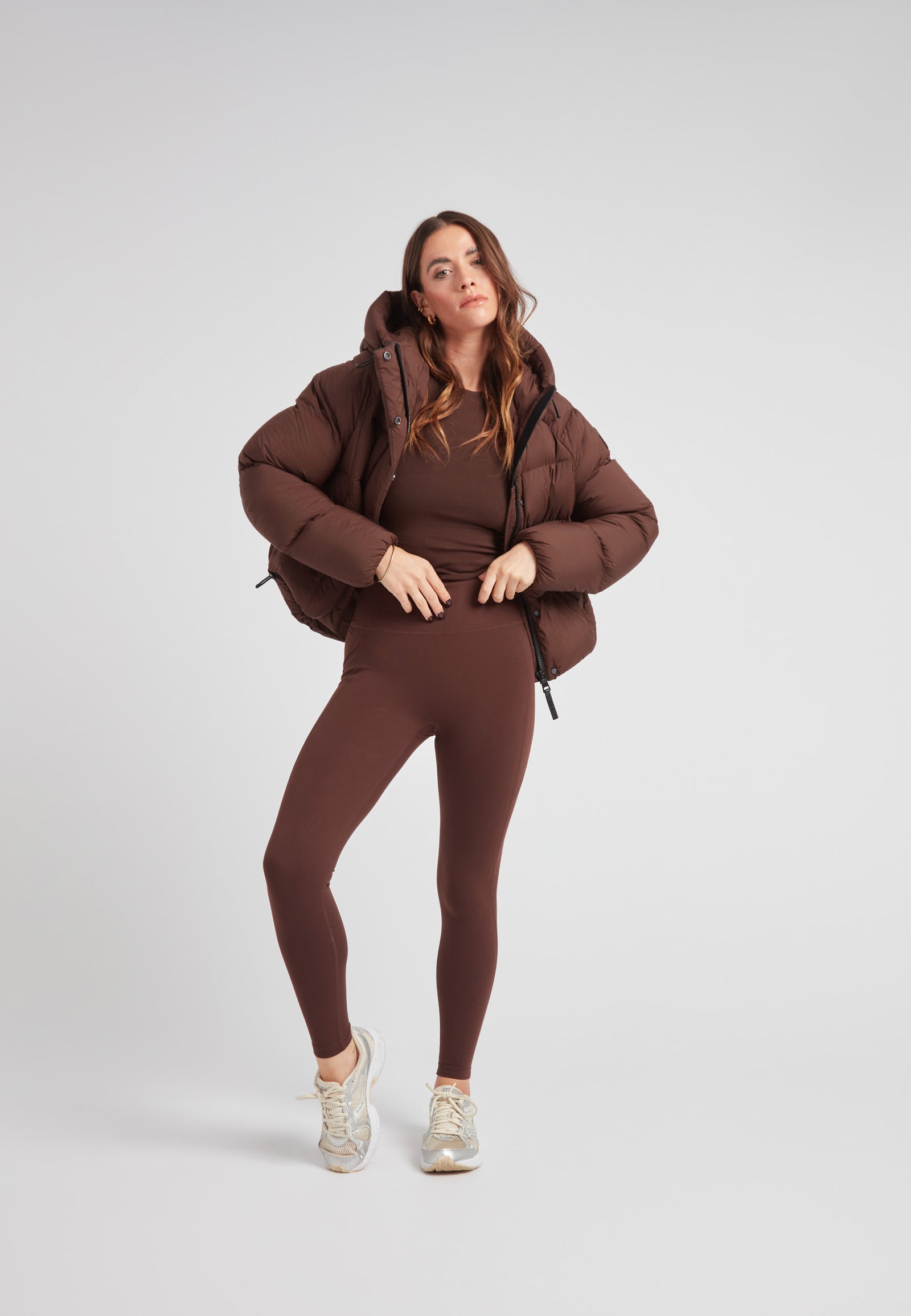 Ladies Cloud Crop Down Puffer Jacket in Mid Brown worn by a woman with matching brown outfit and sneakers.