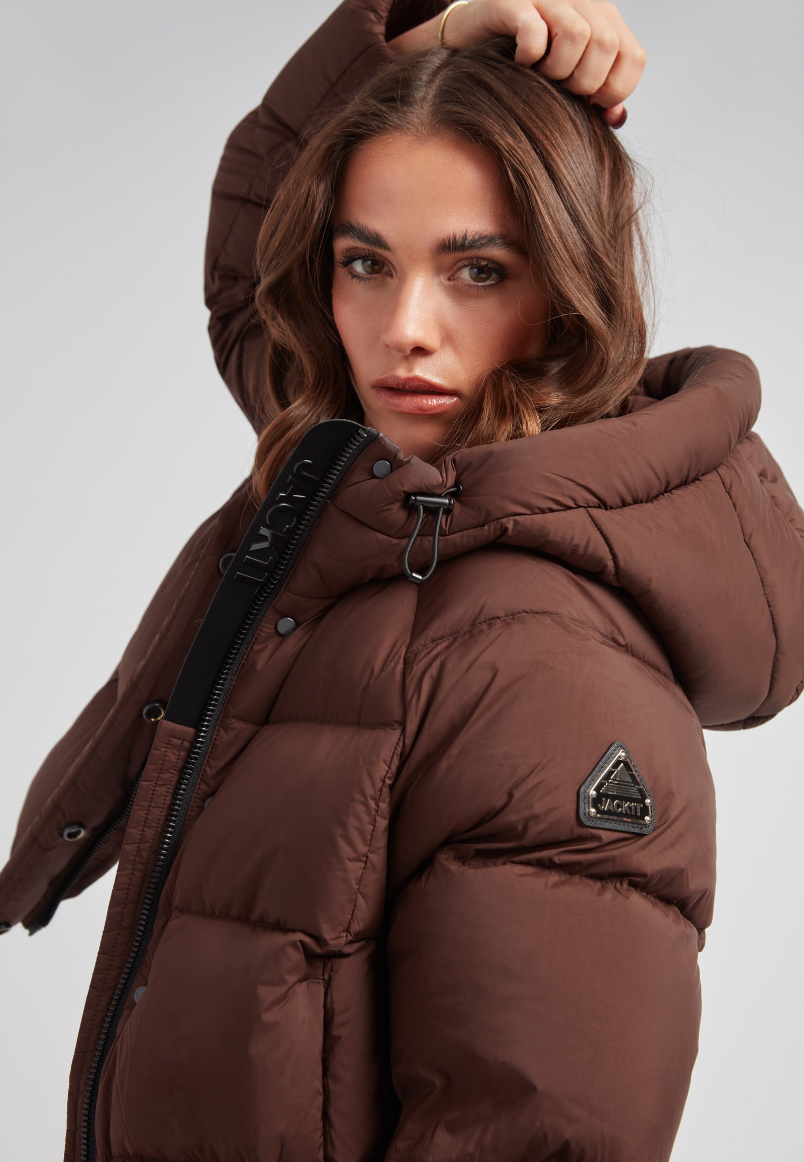 Ladies Cloud Crop Down Puffer Jacket in Mid Brown worn by a model with an oversized hood and stylish silhouette