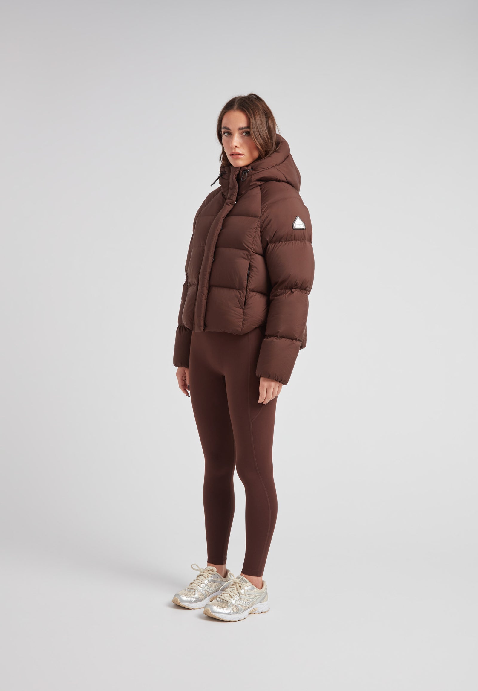 Ladies Cloud Crop Down Puffer Jacket in Mid Brown worn by a model, showcasing its stylish and warm design.