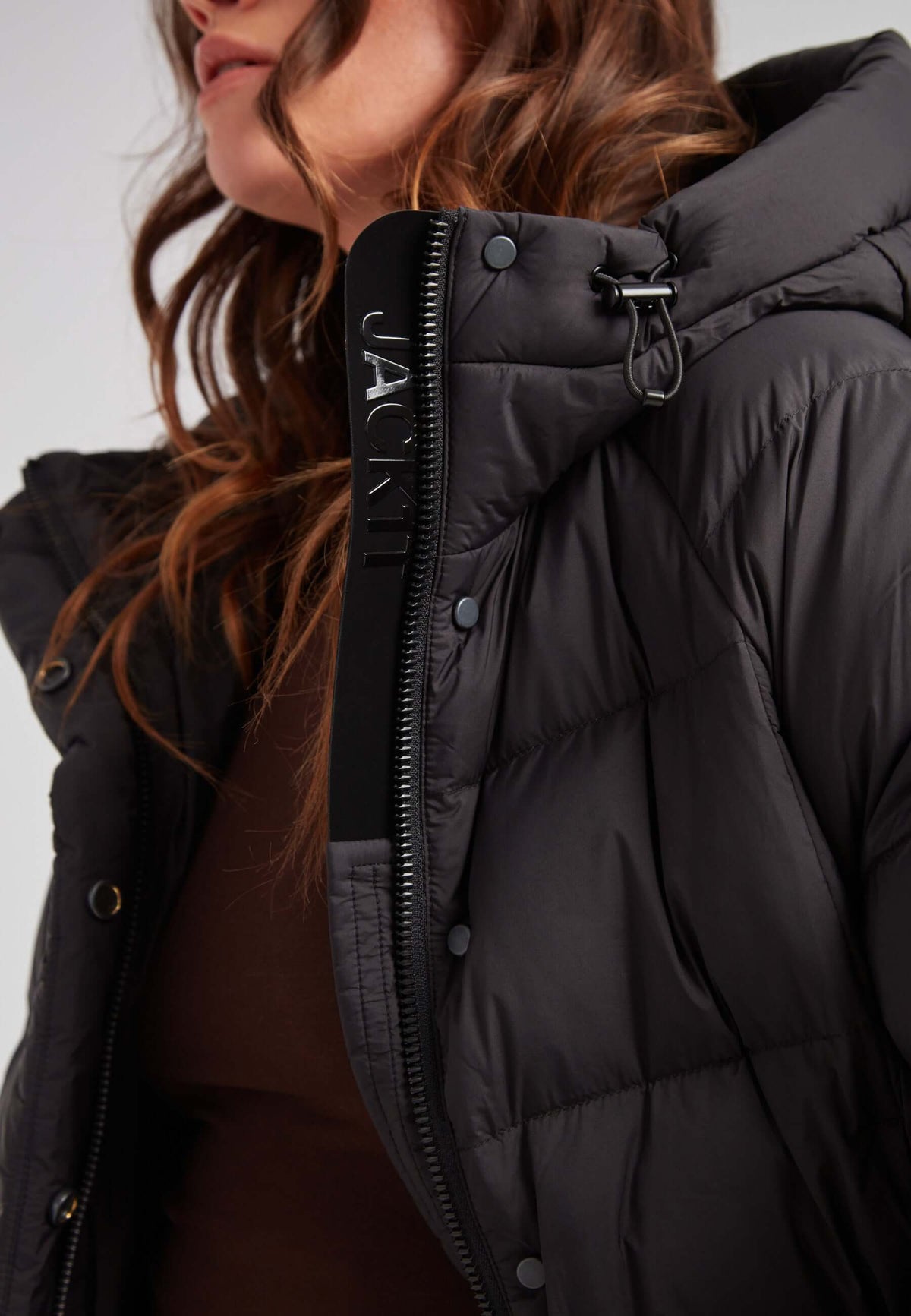 Close-up of a woman wearing a black Cloud Crop Down Puffer Jacket, showcasing oversized hood and lightweight insulation, short puffer jacket women.