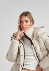 Model wearing Cloud Prime Longline Down Puffer Jacket Stone with adjustable hood and zip detail.