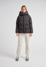 Woman in Cloud Prime Longline Down Puffer Jacket with adjustable hood, styled with cream sweatpants.