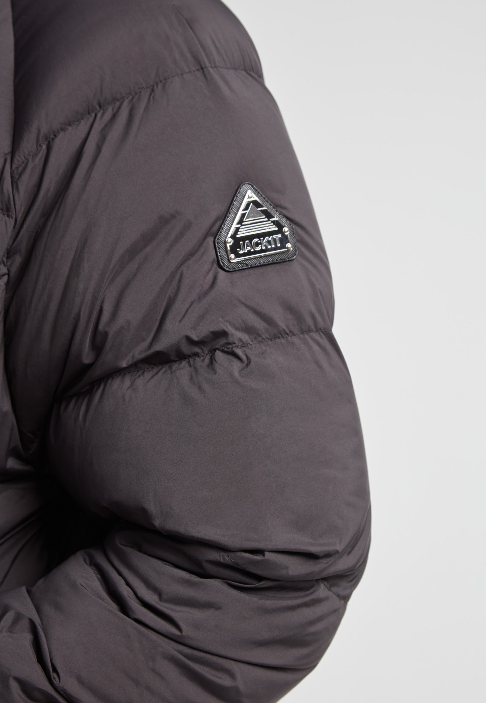 Detail of the sleeve of a Cloud Ultra Long Down Puffer Coat, showcasing the JACK1T logo on black fabric.