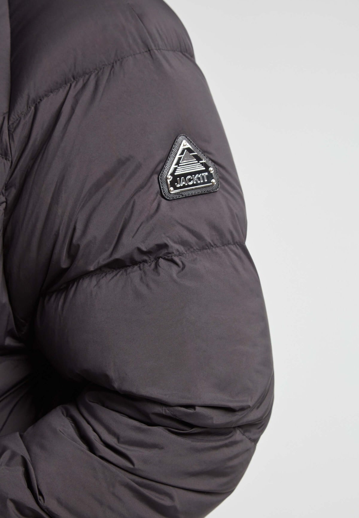 Detail of the sleeve of a Cloud Ultra Long Down Puffer Coat, showcasing the JACK1T logo on black fabric.