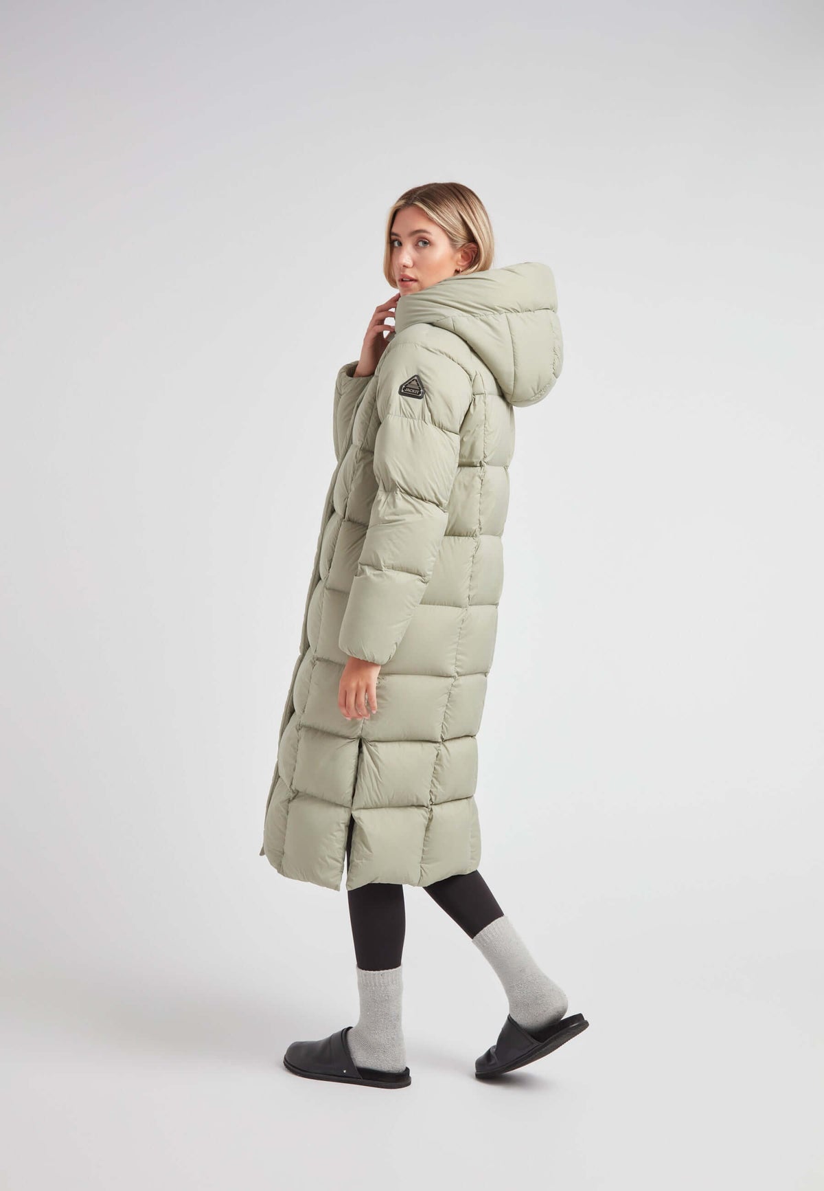 Woman wearing a green Cloud Ultra Long Down Puffer Coat, showcasing its ankle-length and adjustable hood design.