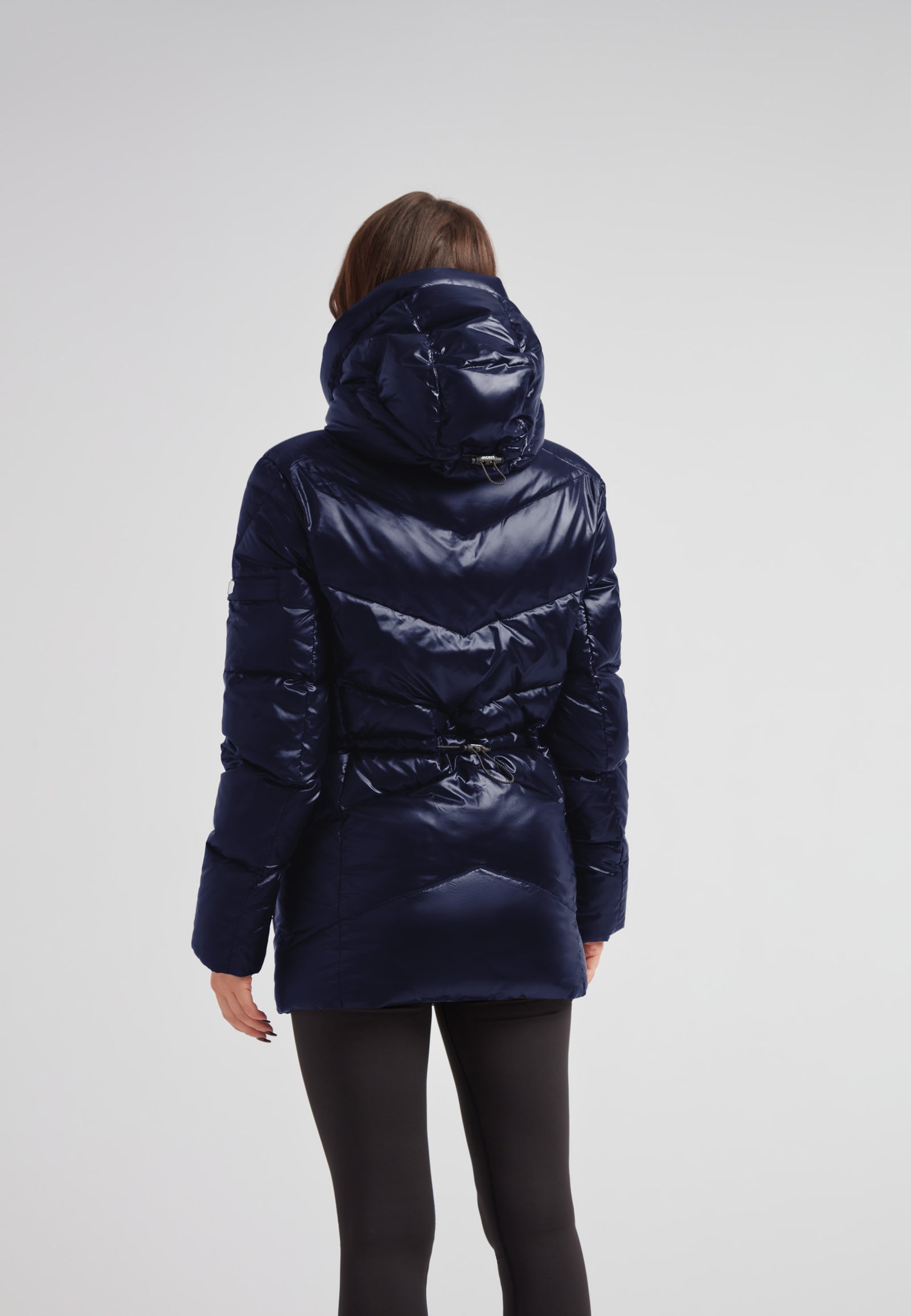 Back view of a woman wearing a Womens navy down puffer coat with adjustable waist and hood.