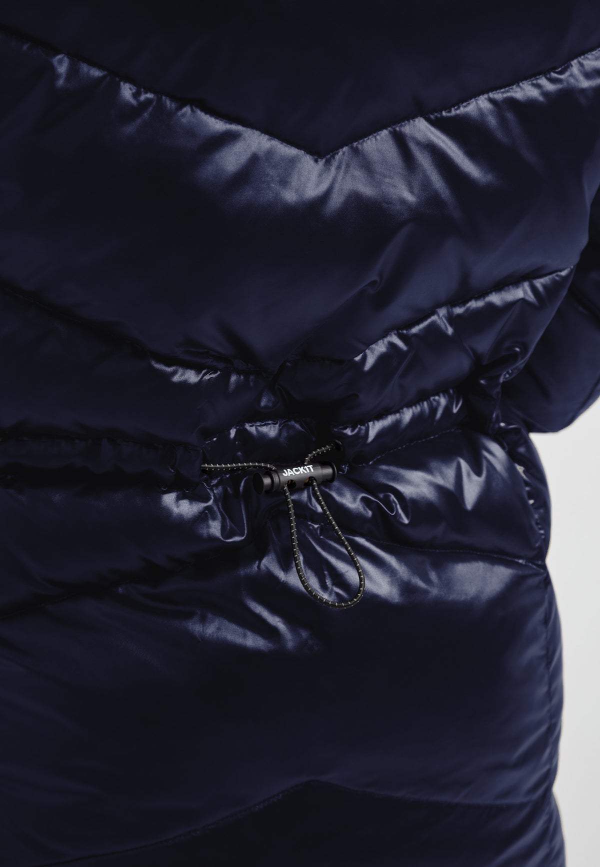 Close-up of the hidden waist toggles on a womens navy down puffer coat for a cinched custom fit.