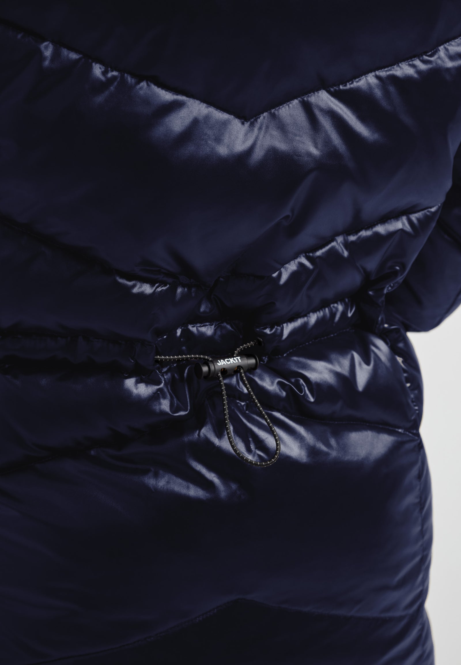 Close-up of the hidden waist toggles on a womens navy down puffer coat for a cinched custom fit.