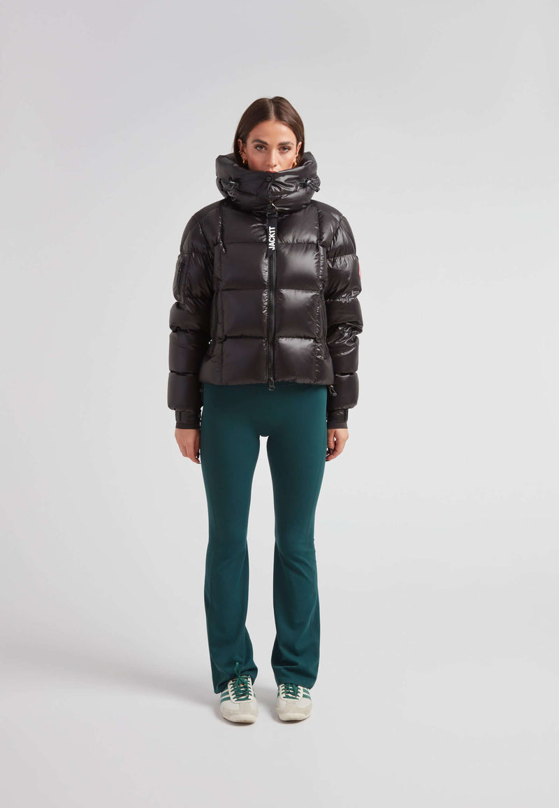 Woman wearing the EZ Boxed Crop Down Puffer Jacket Lux Black with green pants, showcasing winter style and warmth.
