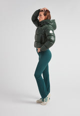 Woman wearing EZ Boxed Crop Down Puffer Jacket Lux Emerald and teal pants, posing confidently in a stylish winter look.