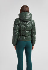 Back view of the EZ Boxed Crop Down Puffer Jacket Lux Emerald paired with green leggings, showcasing its sleek design.