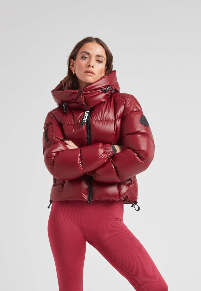 Short down puffer jacket women in luxurious cranberry shade, featuring a cropped fit and adjustable hood.