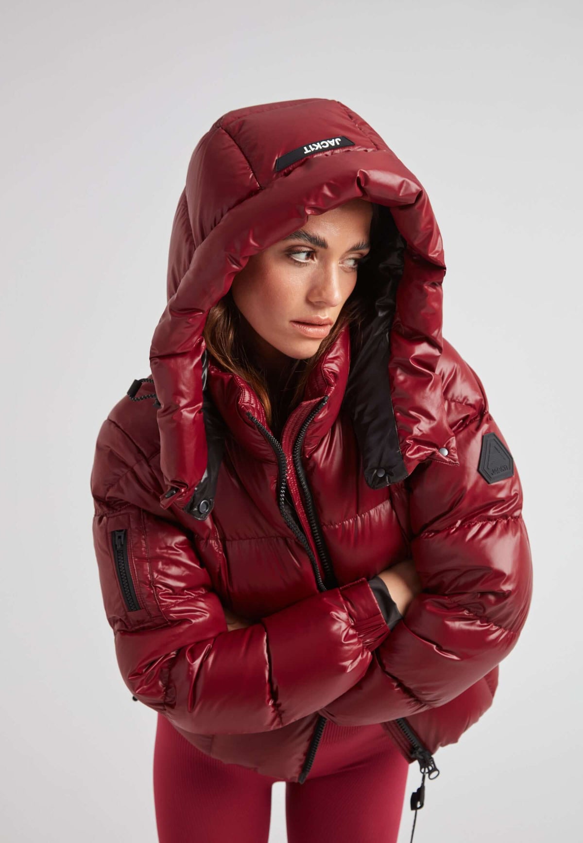 Short down puffer jacket women in lux cranberry color with adjustable hood and bold box quilting.