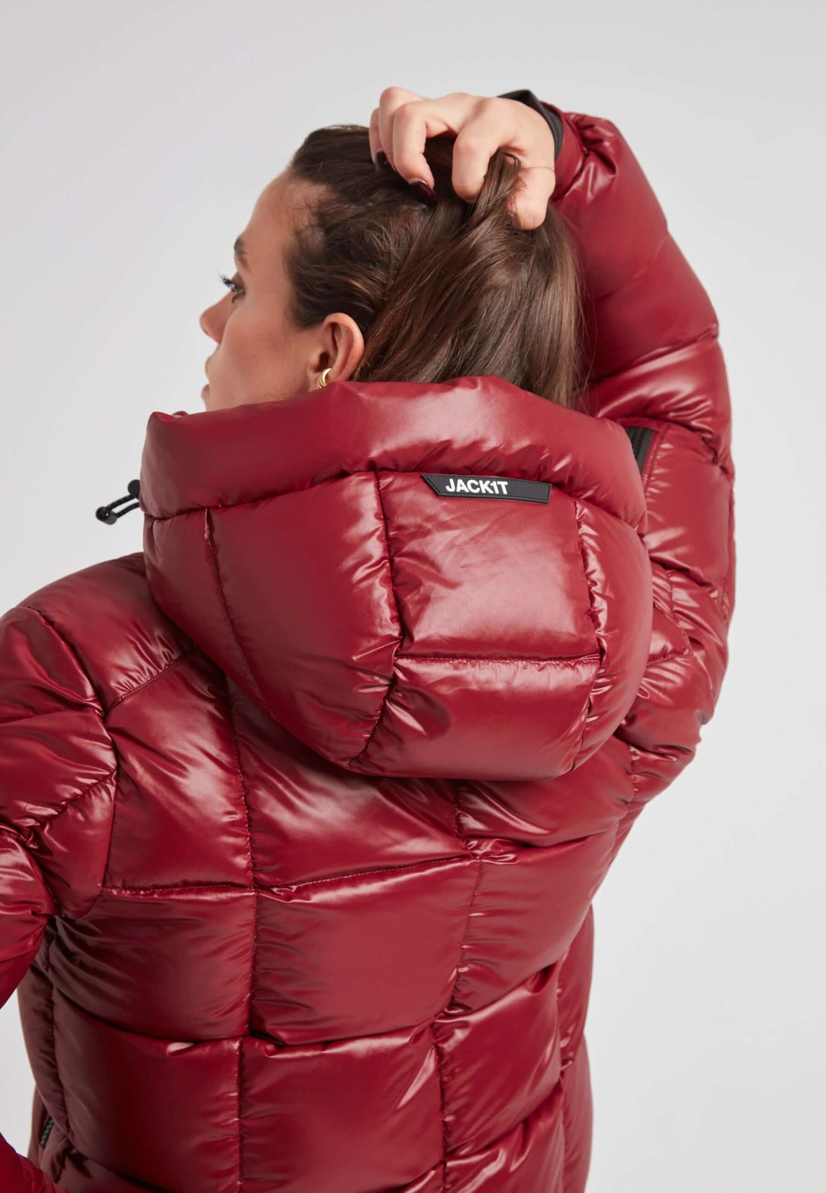 Woman wearing EZ Boxed Crop Down Puffer Jacket in Lux Cranberry, showcasing adjustable hood and bold box quilting. Short down puffer jacket women.