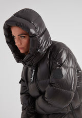 Close-up of a woman wearing the EZ Boxed Ultra Long Down Puffer Coat Lux Black with a hood.