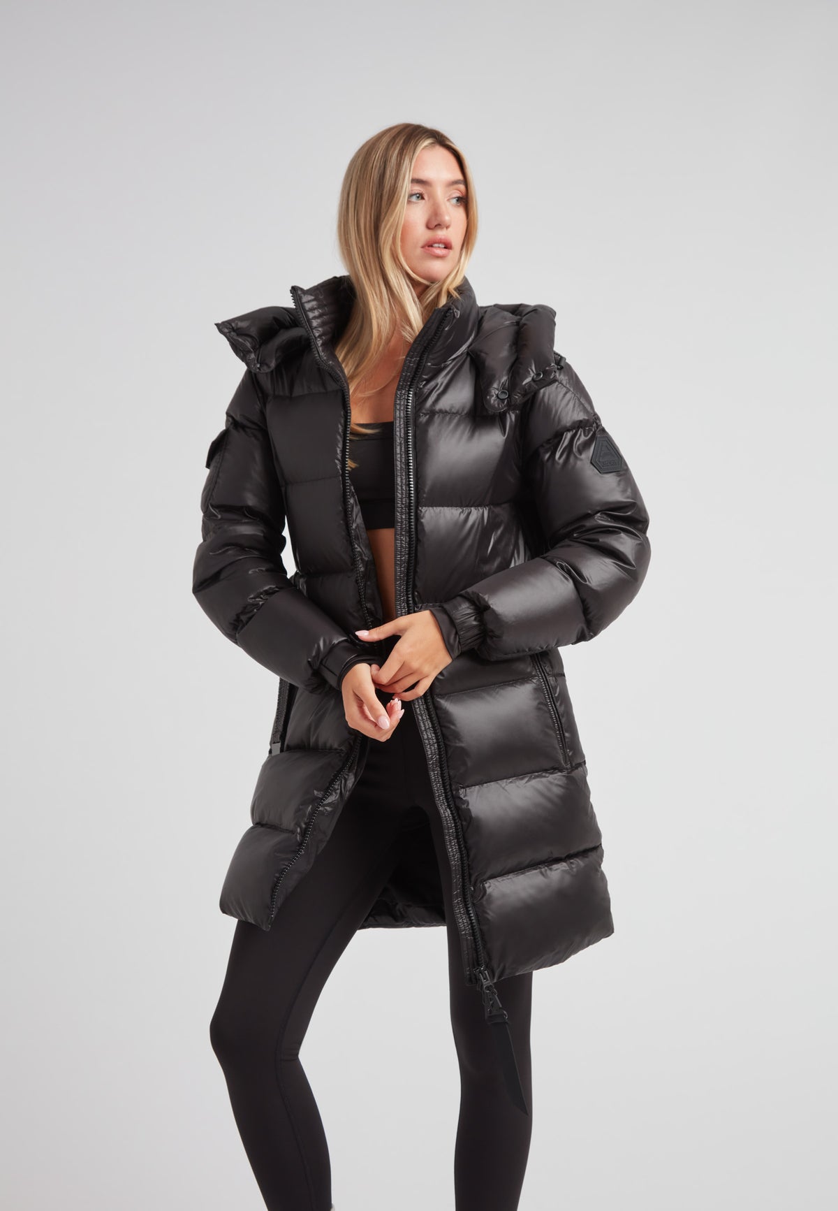 EZ Belted Down Puffer Coat Lux Black on a stylish model, showcasing winter fashion with a sleek, insulated design.