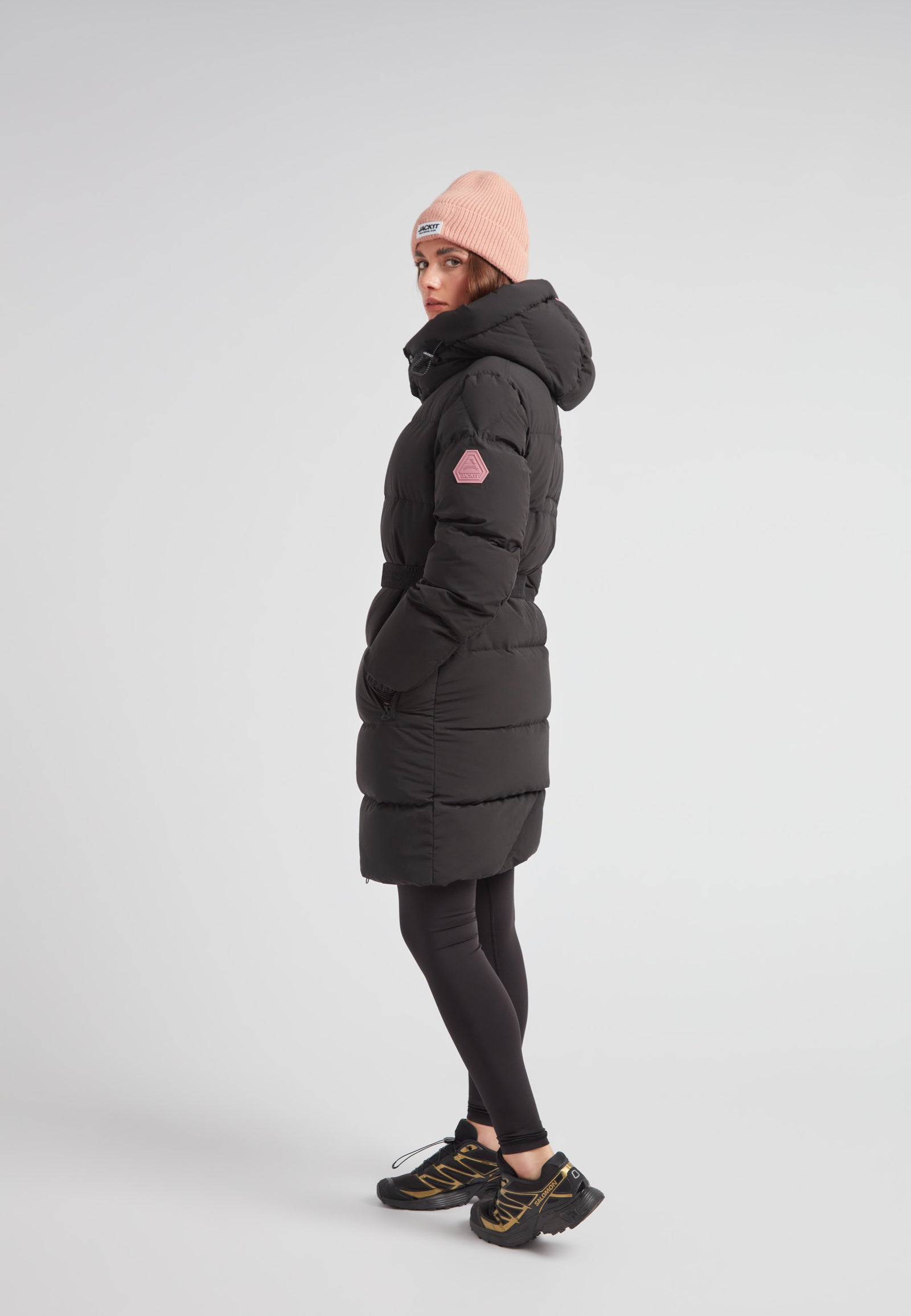 Model wearing EZ Belted Down Puffer Coat Matt Black with a pink beanie, showcasing winter style and comfort.