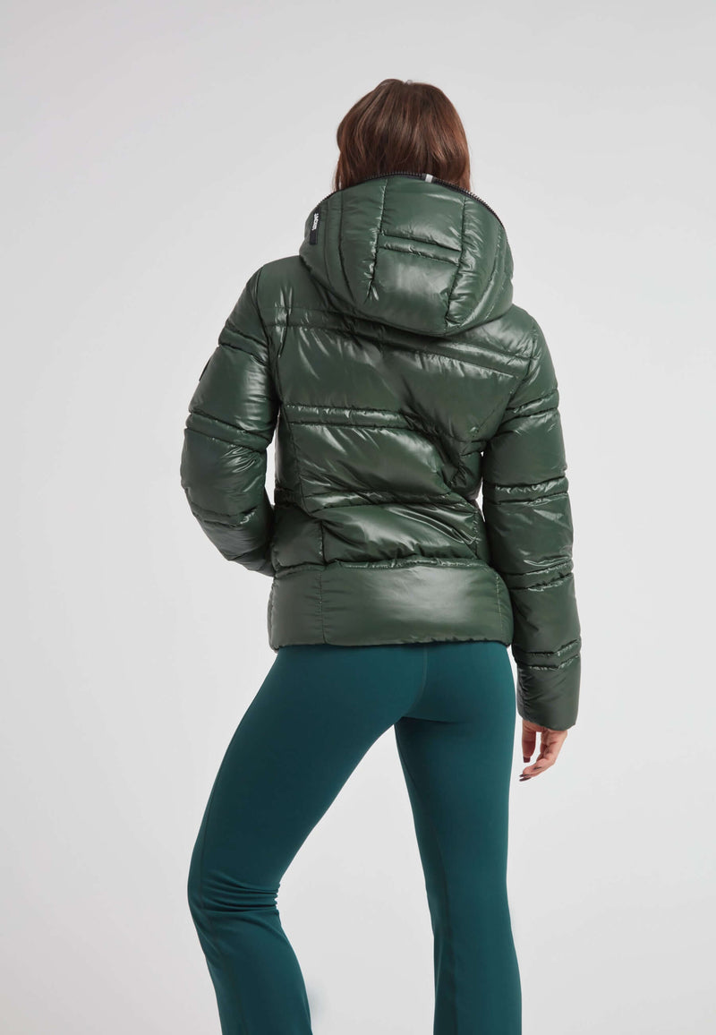Back view of a woman in the R4D Tramline Puffer Racer Jacket Lux Emerald with a hood, showcasing its sleek design.