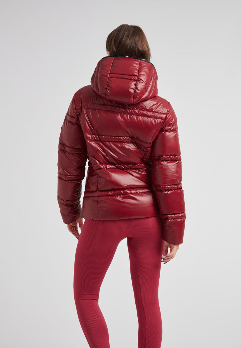 Woman wearing R4D Tramline Puffer Racer Jacket Lux Cranberry with a hood, showcasing the back of the jacket.