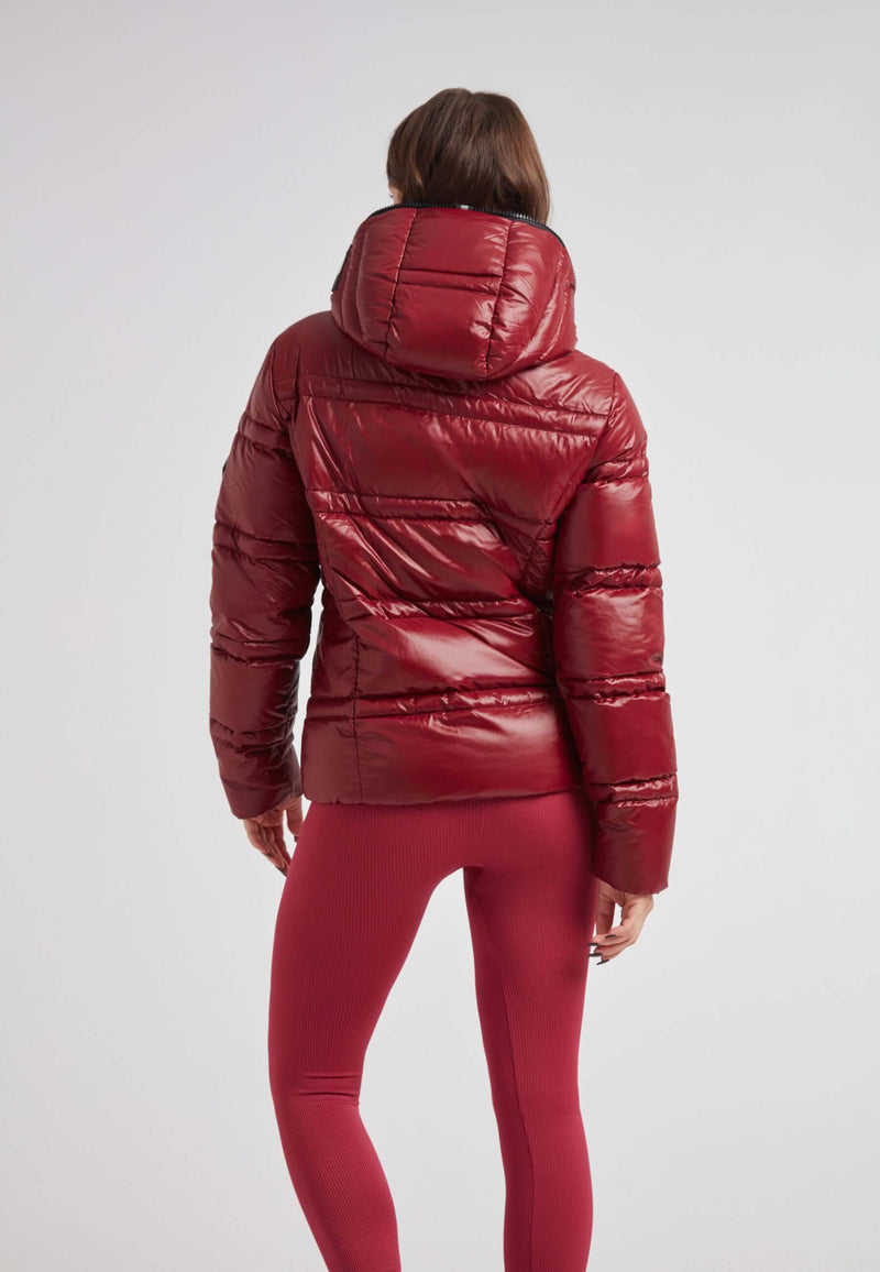 Woman wearing R4D Tramline Puffer Racer Jacket Lux Cranberry with a hood, showcasing the back of the jacket.