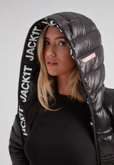 Woman wearing the R4D Tramline Down Coat Lux Black with hood up, showcasing elegant design and JACK1T branding.